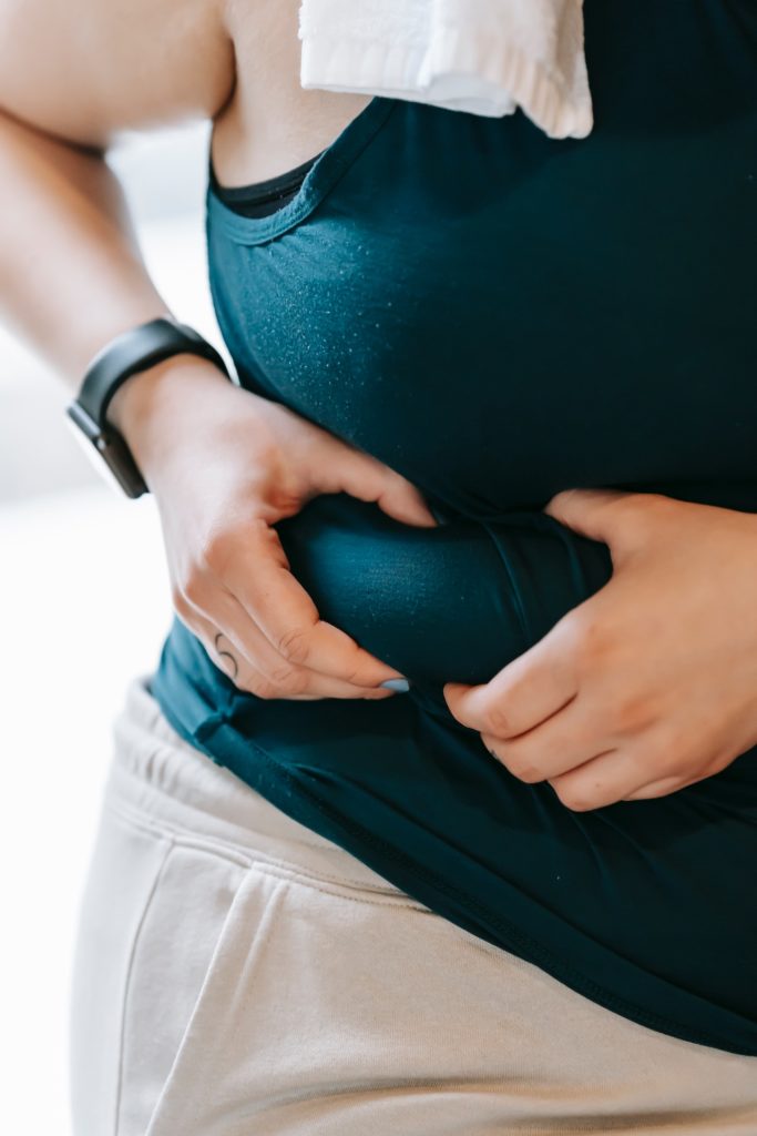 woman holding fat around midsection